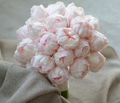 a bouquet of pink flowers sitting on top of a cloth