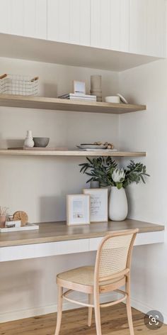 a chair and desk in a room with open shelves on the wall above it, along with other items