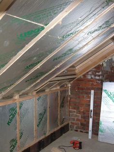 an unfinished room with some insulation on the ceiling and walls in place to be installed