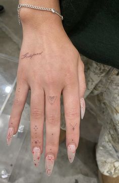 a woman's hand with pink and white nail polishes on her left thumb