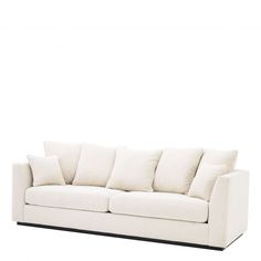 a white couch with several pillows on it's back and side, against a white background