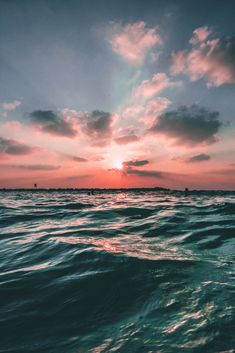 the sun is setting over the ocean as it reflects in the water's surface