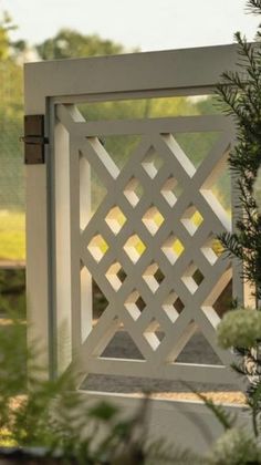 a white wooden gate surrounded by greenery