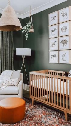 a baby's room with green walls and pictures on the wall, including a crib