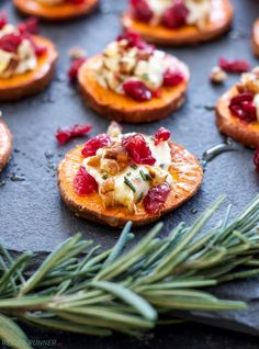 small appetizers with cranberries and cheese are on a baking sheet, ready to be eaten