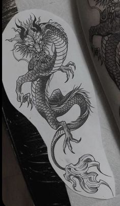 a black and white photo of a dragon tattoo on the leg, next to a woman's legs