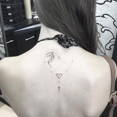 a woman with a cross and heart tattoo on her back