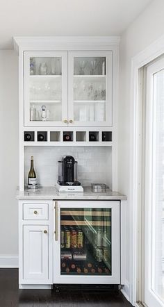 a kitchen with white cabinets and glass doors on the front door is shown in this image