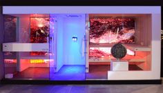 the entrance to an indoor spa is lit up with blue and red lights at night