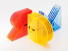 three different colored plastic objects on a white surface