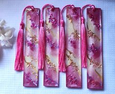 four pink bookmarks with tassels and flowers