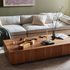 a living room with a couch, coffee table and pillows on the floor in front of it