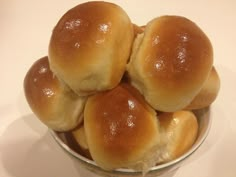 a bowl filled with rolls sitting on top of a table