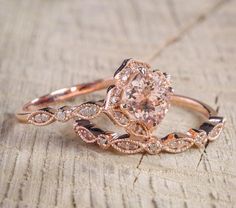 a close up of a ring on top of a piece of wood with an oval shaped diamond in the center