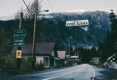 a street sign on the side of a road with mountains in the background