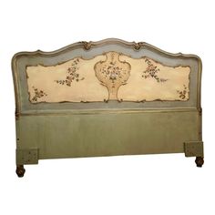 an old fashioned bed with floral designs on the headboard