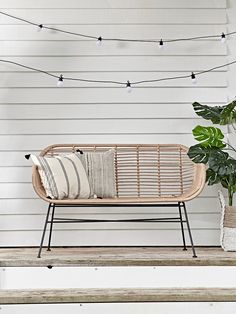 a wooden bench sitting next to a potted plant on top of a step case