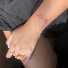 a person with a small tattoo on their left wrist and the word love is in red ink