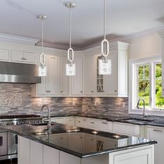 a large kitchen with white cabinets and stainless steel appliances, along with marble counter tops