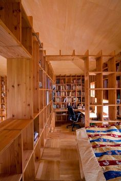 a bedroom with wooden walls and shelves filled with books