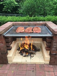 an outdoor bbq grill with steaks cooking on it's sides and fire in the middle