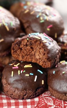 chocolate donuts with sprinkles on a red and white checkered cloth