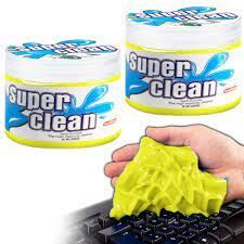 three jars of super clean on top of a computer keyboard and hand holding a sponge