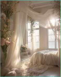 a white bedroom with sheer curtains and flowers on the bed