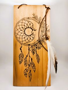 a wooden plaque with an image of a bird and feathers on it, next to a feather quill