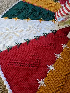 a close up of a knitted blanket on the ground with candy canes in it