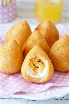 some fried food on a plate with a glass of orange juice in the back ground