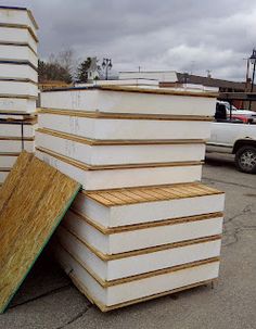 several stacks of boards stacked on top of each other in front of a white truck