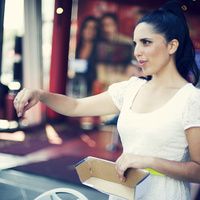 a woman holding a box and pointing at something