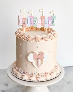 a birthday cake with pink frosting and decorations on top that says sutilong