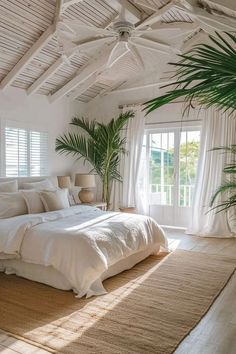 a large bed sitting under a window next to a potted plant in a bedroom