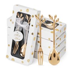 a box filled with gold colored utensils next to a white and gold polka dot package