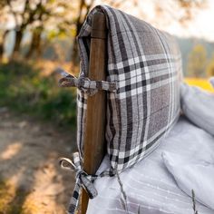 the back end of an outdoor chair with a plaid blanket wrapped around it and tied up