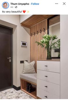 an entryway with a bench, mirror and flowers on the shelf next to it