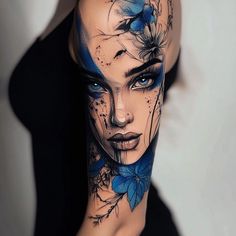 a woman's face with blue flowers and butterflies on her arm, painted in black