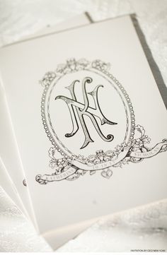 the monogrammed letter k is displayed in an ornate frame on top of two folded cards