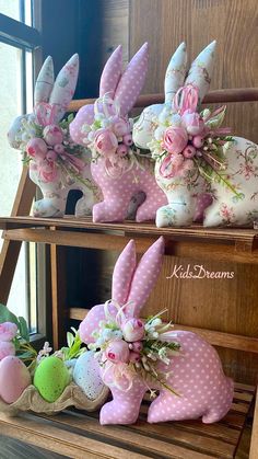 some pink and white bunny statues sitting next to each other