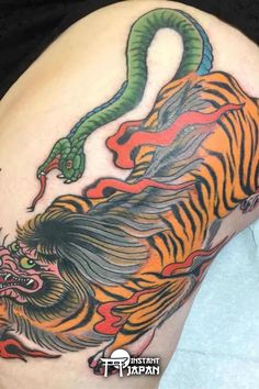 a tiger and dragon tattoo on the thigh