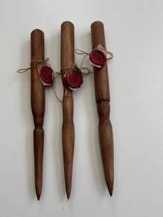 three wooden sticks with red wax on them are tied up to each other and placed next to each other