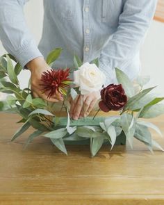 a person is arranging flowers on a table