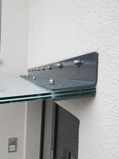 there is a glass shelf on the wall with metal brackets and rivets attached to it