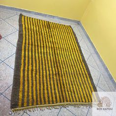 a yellow and black striped rug on the floor