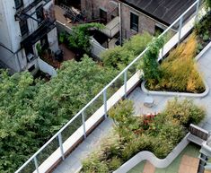 an aerial view of a rooftop garden with benches and plants growing on the side of it