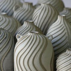 many white vases are stacked on top of each other in the shape of waves