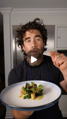 a man holding a plate with food on it