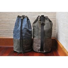 two bags sitting next to each other on a wooden floor in front of a wall